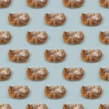 Puff pastry buns of fancy shape, with crumbs, on a blue background, pattern
