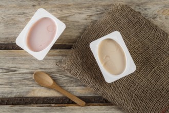 Natural organic yogurt with natural juice on a wooden background with a natural bamboo spoon
