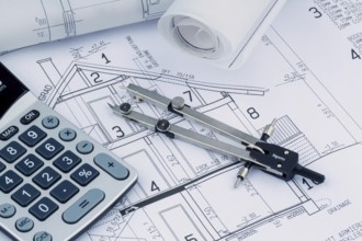 An architect's construction plan with a calculator. Symbolic photo for financing and planning a new