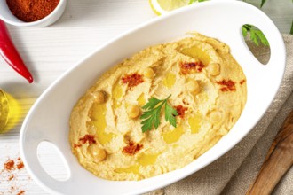 Hummus paste with lemon and chilli on a white background
