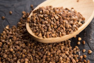 Buckwheat seeds on wooden spoon in closeup, lodz, poland