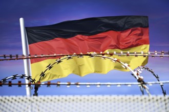 German flag in front of barbed wire, symbolic photo for border controls and rejection at the German