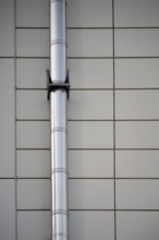 A mounted stainless steel pipe on a symmetrically arranged sheet metal façade