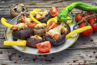 Easy appetiser of mushrooms stuffed with cheese, garlic and tomatoes.Rustic kitchen.Photo tinted