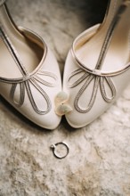 Women's earrings in the shape of leaves on the toes of the bride's white shoes with an engagement