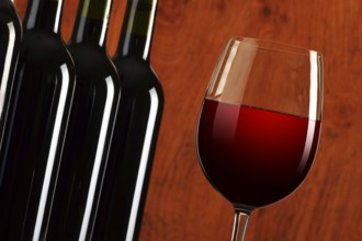 Composition with wineglass and bottles of red wine