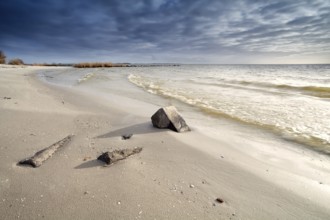 Deep sky cloudscape over sand beach on North sea