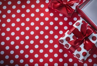 Present boxes on polka-dot red print background celebrations concept