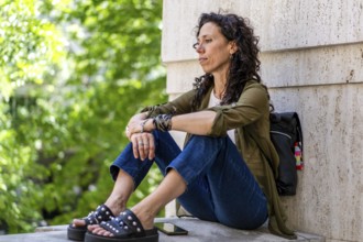 Mid-adult woman sitting on a ledge