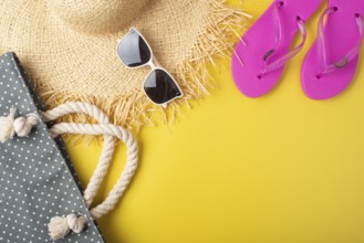 Flip flops straw hat sunglesses and beach bag on yellow background vacation travel planning mockup