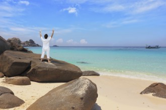 Middle-aged woman dressed in white doing yoga. Asana Blessing of the Sun. Thailand. Gorgeous beach