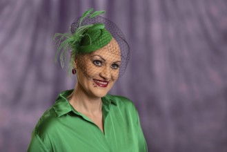 Woman smiling with green hat and net in front of purple background, Staged portrait shoot, Studio
