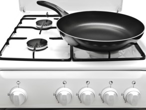 Frying Pan At The White Gas Stove Over The White Background