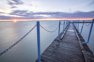 Water landscape, taken from the shore of a calm lake. View over the reflecting water to the horizon