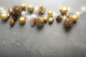 Flat lay view at Christmas decorations of gold and yellow cones glass balls and light garland on