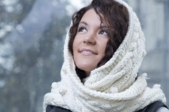 Pretty young caucasian brunette woman wearing white scarf with hood in a outdoor winter portrait