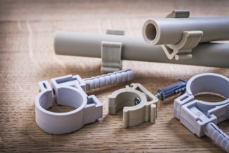Composition Polypropylene Fixators And Pipe With Clips On Wooden Board
