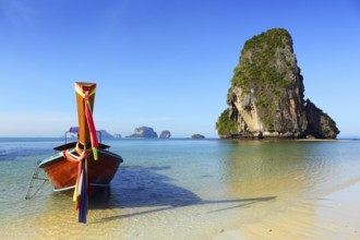 Long tail boat on tropical beach (Pranang beach) and rock, Krabi, Thailand, Asia