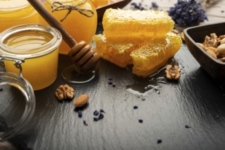 Honeycomb on slate tray with honey and nuts on kitchen table, food photography, food photography