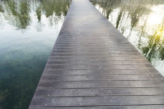 Infinitely long pedestrian bridge over a lake with reflections