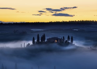 Tuscany farmhouse in morning mist with yellow skies, Val d'Orcia, Italy, Europe