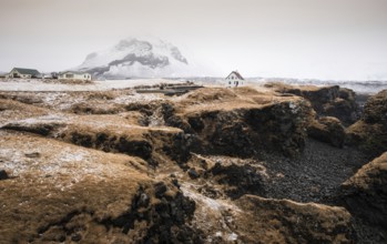 Icelandic landscape with a white small beautiful house in winter under the mountain at Arnarstapi