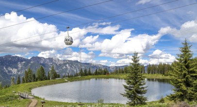 Small lake on the Planai with gondola lift. Smal water reservoir on a mountain by schladming,