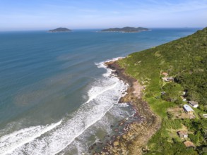Coastline with beach, mountains and blue ocean with waves in Brazil. Aerial view of Saquinho beach.