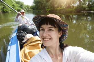 Man and woman couple, baby is sleeping, selfies are happy in family kayak trip rowing boat on the