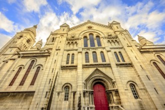 Left side facade and door of Basilique Sacred Heart in Montmartre of Paris in France with no people