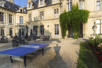 Ping-pong table in the courtyard of the castle Grand Mello. France. Sunny day in August