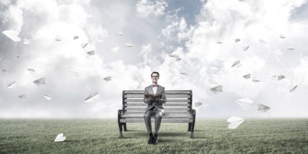 Young businessman or student studying the science and paper planes fly around