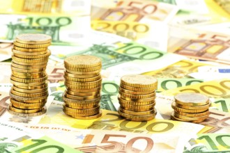 Stack of coins, falling curve, symbolic photo for falling interest rates and falling costs