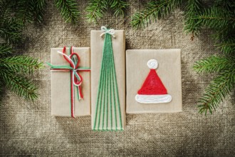 Set of fir tree branches handmade gift boxes on burlap background