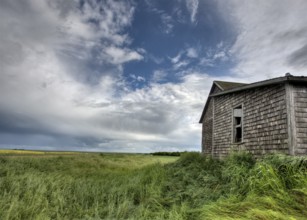 Abandoned Farm with storm clouds in the Canadian Prairie