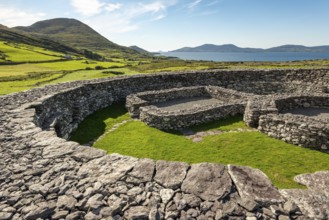 Loher Stone Fort at Caherdaniel overlooking green pastures and the sea under a clear blue sky, Ring