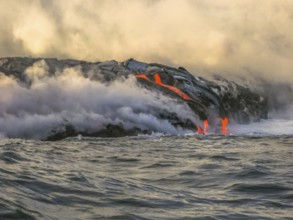 Volcanic activity with smoke and steam given off by lava contact with Pacific Ocean. Kilauea