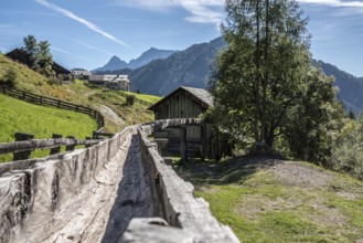 An old wooden inlet channel of a watermill in Val di Morins, the Dolomite Alps of South Tirol