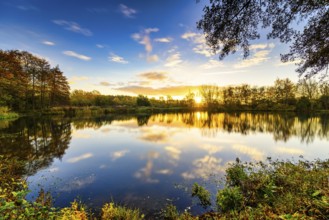 Beautiful sunrise at the lake with reflection in the water and clouds moving