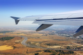 Airplane takeoff from Madrid Barajas over golden wheat fields