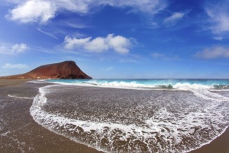 Beach Playa de la Tejita turquoise in Tenerife Canary islands with red mountain