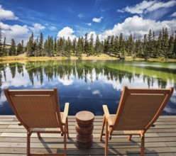 Two wooden deckchairs for tourists on ashore shallow round lake. Autumn day in Jasper National Park