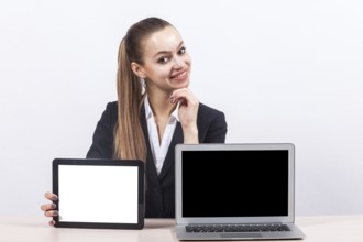 Attractive young caucasian businesswoman with ponytail in black suit sit at the office desk and