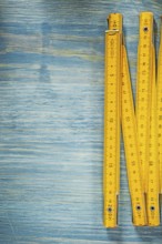 Yellow wooden meter on vintage wood surface construction concept