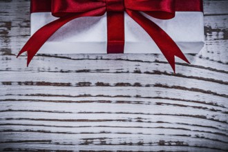 Present box on vintage wooden board top view holidays concept