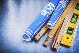 Blue engineering drawings wooden meter construction level on metallic background