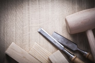 Wooden bricks mallets flat chisels on wood background close up view construction concept