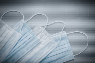 Set of disposable medical flu masks on a striped background