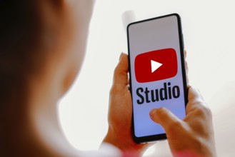 In this photo illustration, the YouTube Studio logo is displayed on a smartphone screen