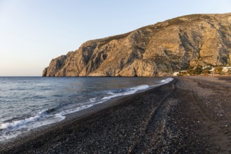 Morning atmosphere, rocky cape Mesa Vouno, lava beach Kamari Beach, Santorini, Cyclades, Greece,